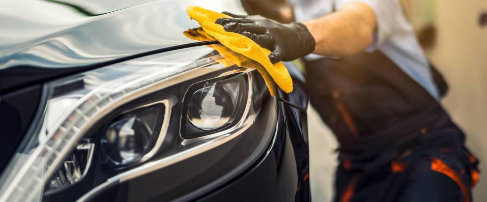 person-cleaning-car-headlight-with-yellow-cloth