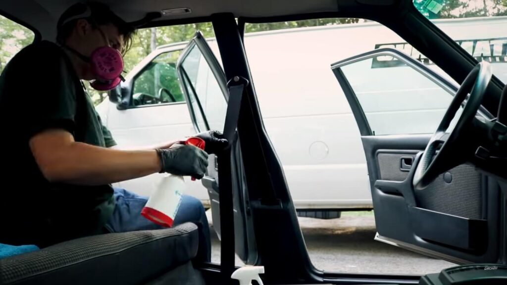 Cleaning a car with protective equipment